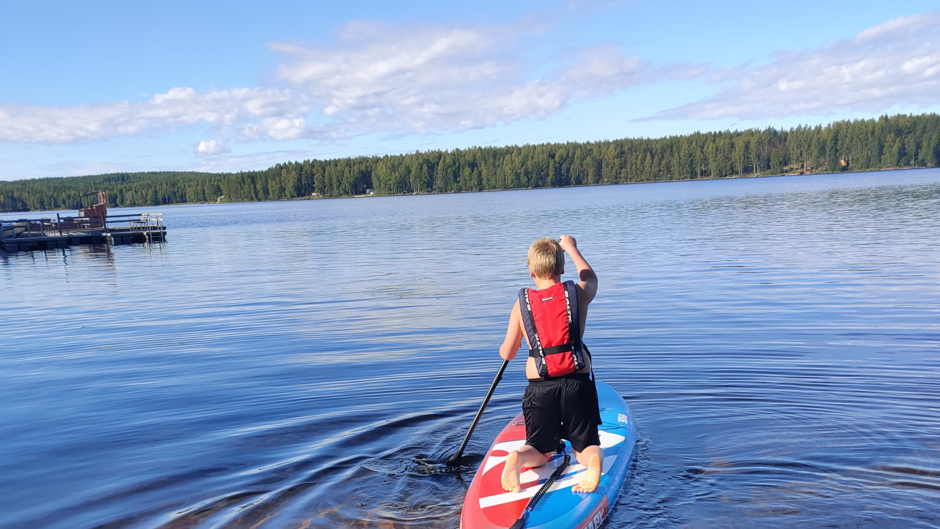 Poika subbailemassa järvellä